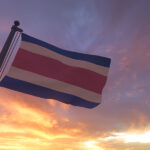 Costa Rica-flag on flagpole by evening sunset sky